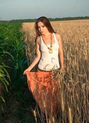 Teaser with a firm booty and big boobs posing in a field seductively